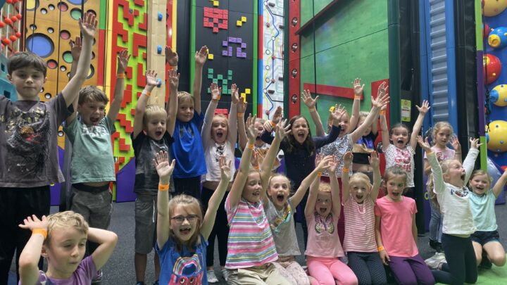 Group of young kids cheering with their hands up at a Clip 'n Climb birthday party in High Rise in Lisburn