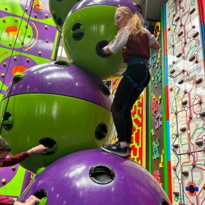 School student climbing on the Astroball climbing challenge at High Rise Clip 'n Climb