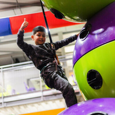 Young boy giving a thumbs up on the Astroball Clip 'n Climb challenge at High Rise Adventure Centre Lisburn