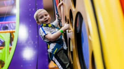 young boy on climbing wall in Clip 'n Climb at High Rise Lisburn