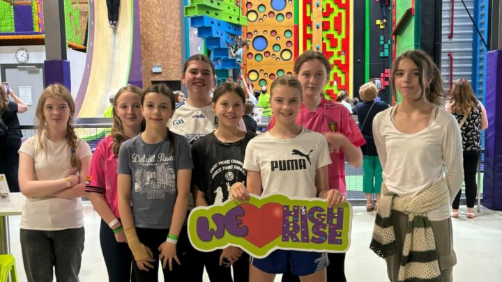 Co Monaghan youth group visit to High Rise Lisburn - group of young people holding We Love High Rise sign in front of Clip 'n Climb arena