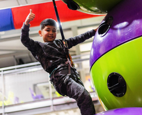 Young boy giving the thumbs up on a climbing challenge at High Rise Lisburn