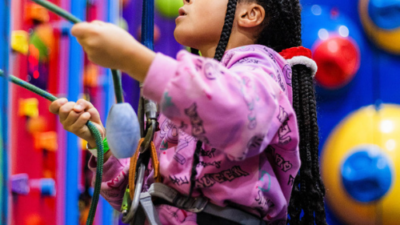 Young girl focusing hard on a climbing challenge at Clip in Clip at High Rise Lisburn