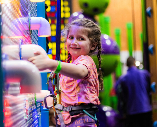 Young girl smiling on climbing walls at High Rise Lisburn